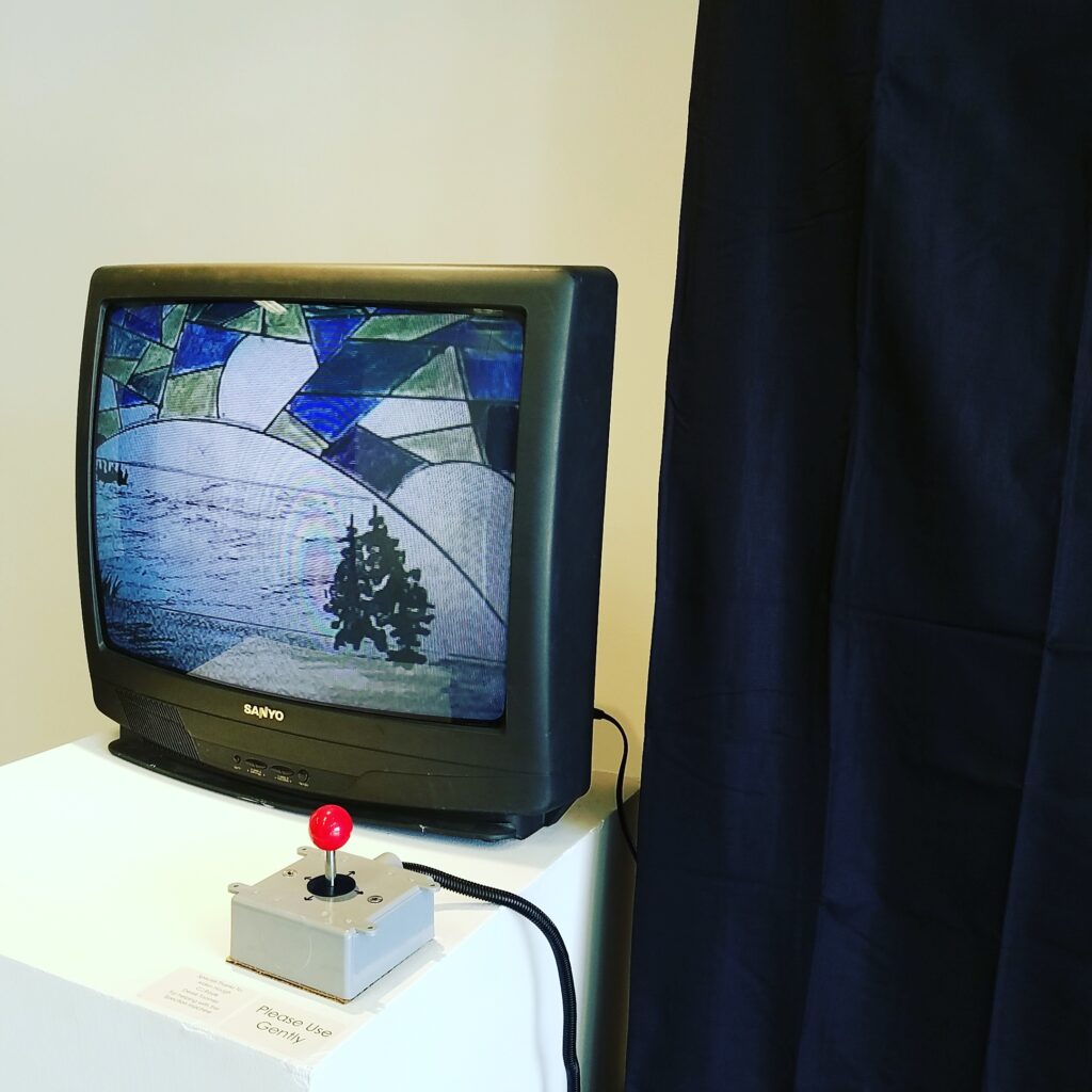 A live view camera sits on an x/y gantry. Viewer can navigate the drawings behind the curtain by commandeering the joysticks.