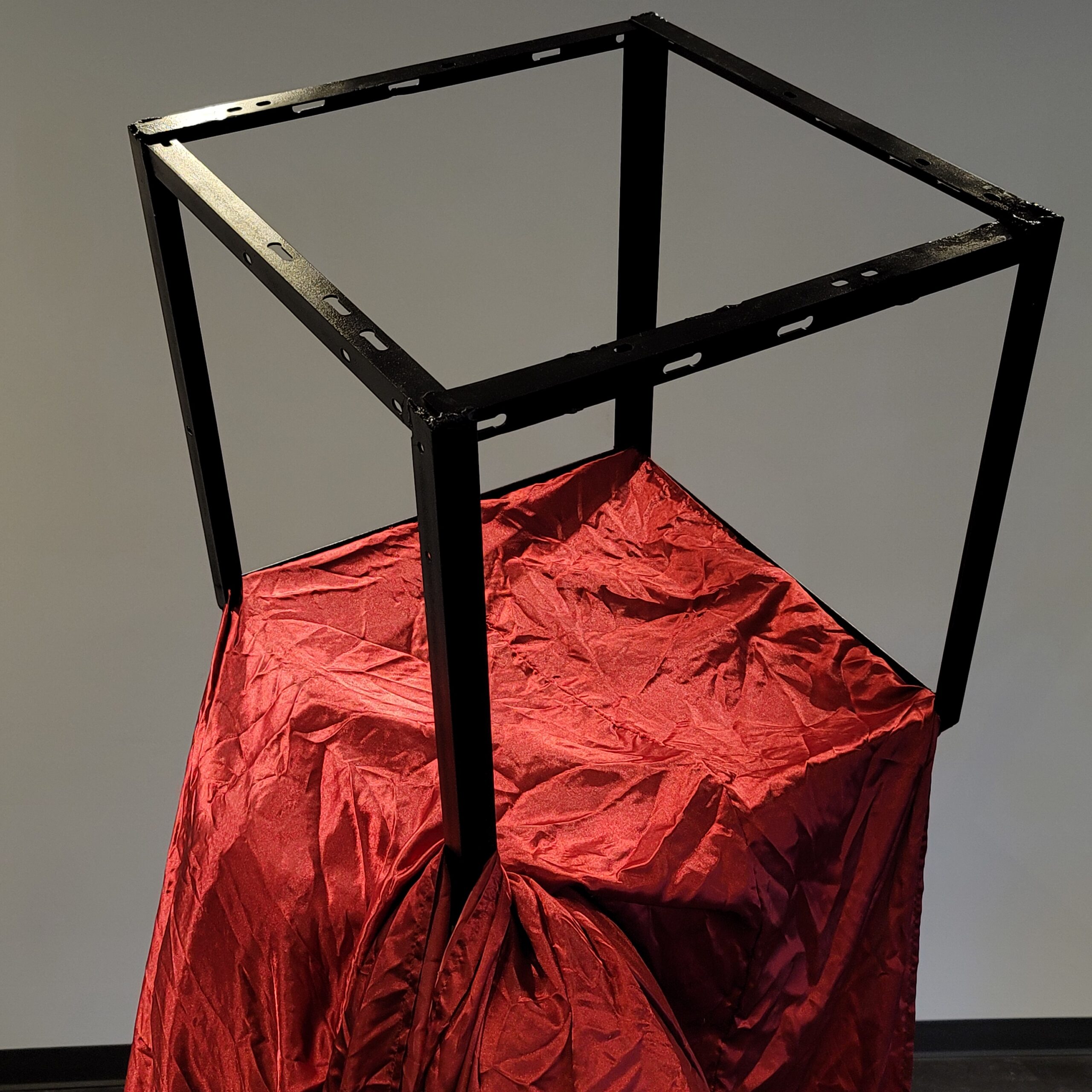 Cube metal form with satin bed sheet